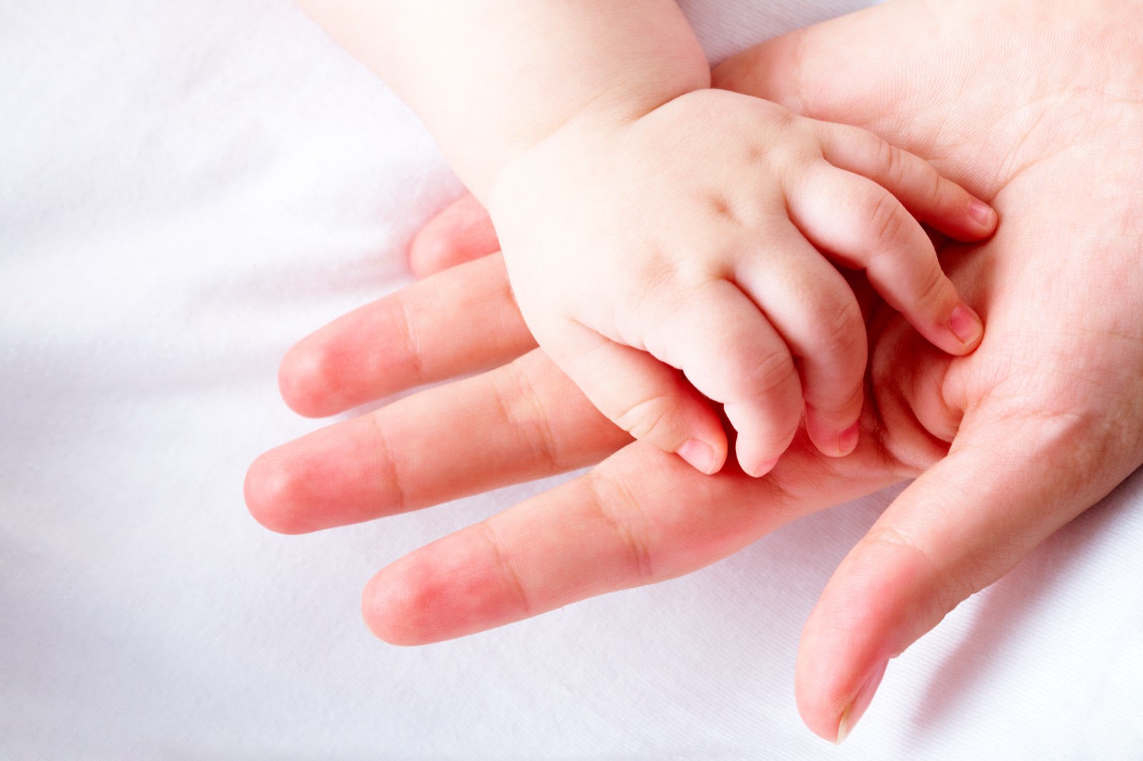 La mano de un bebé sobre la de su madre, el objetivo de los Programas Multiciclo